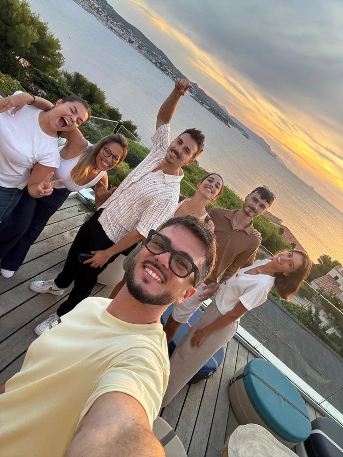 L’équipe du tournage réunie sur une terrasse face à la mer, au coucher du soleil
