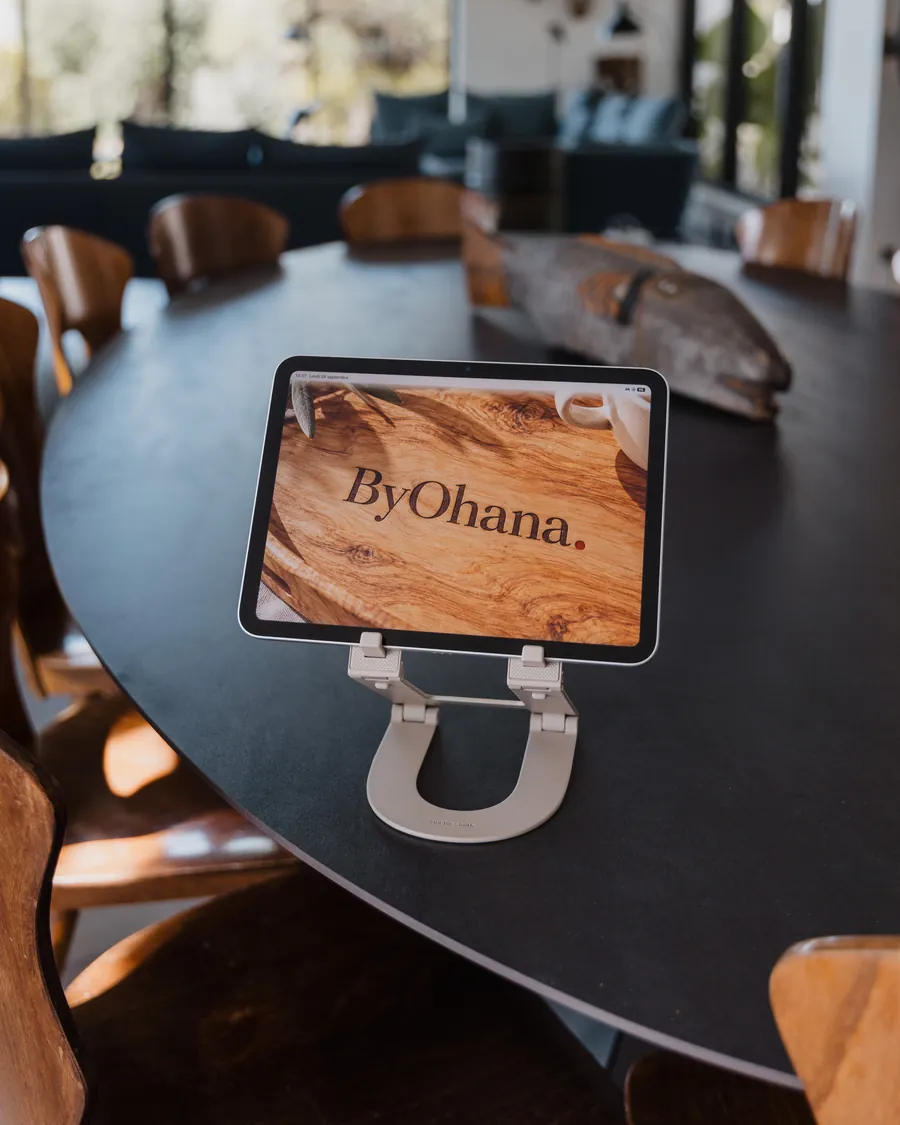 La tablette ByOhana posée sur la grande table en bois d’une villa