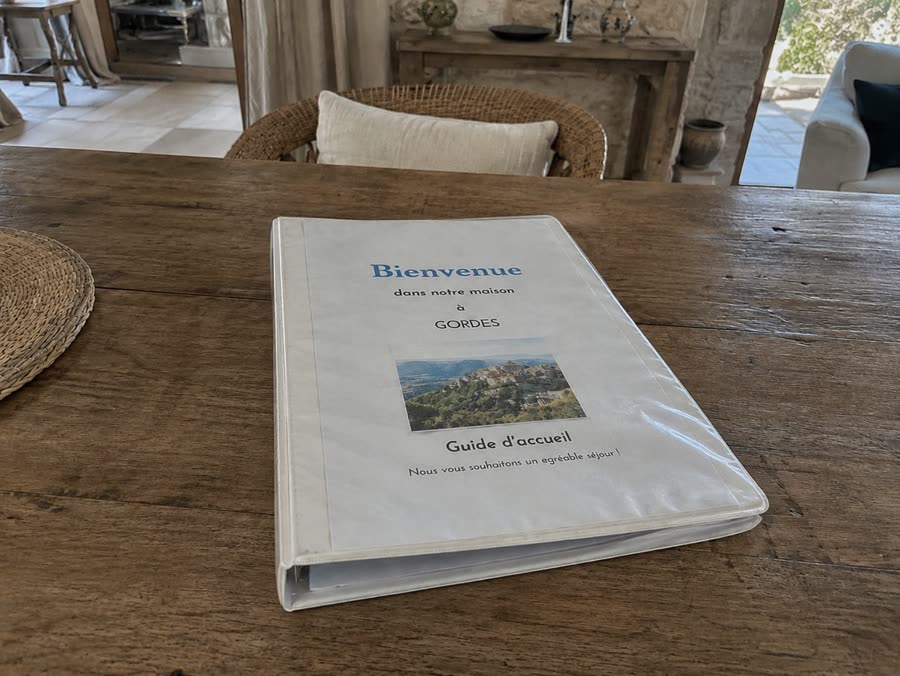 Un classeur d'accueil papier plastifié posé sur une table en bois