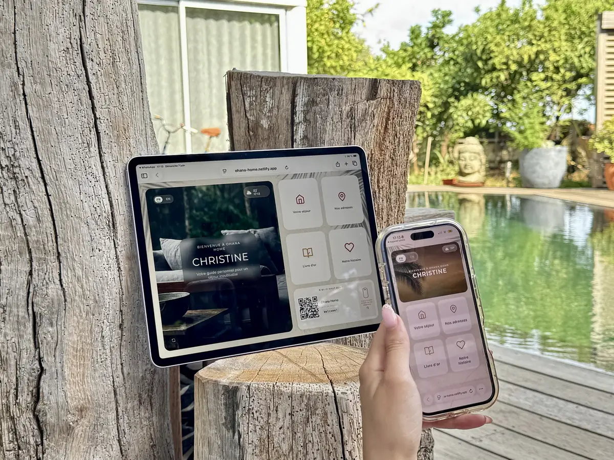 Le guide ByOhana ouvert sur une tablette et sur un téléphone, au bord de la piscine d’une villa